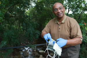 A trained volunteer collects water samples from a public bridge. Photo: CRK